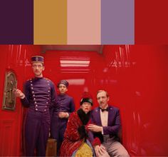 a group of people standing next to each other in front of a red wall with different colors