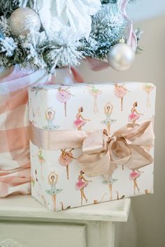 a present wrapped in pink and white wrapping paper with a ballerina design on it