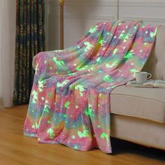 a couch covered with a pink and green blanket