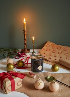 a table with pink and gold baubles, wrapping paper and a can of chatelaine paint. In the background is gold candle sticks Gold Effect, Festival Diy, Best Seasons, Christmas Spirit, Diy Projects