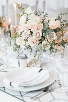 the table is set with white and pink flowers