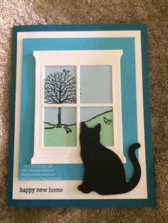 a card with a black cat sitting in front of a window that says happy new home