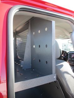 the back end of a red truck with holes in it's cargo compartment and its door open