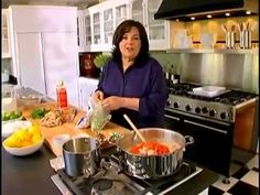 a woman standing in a kitchen preparing food on top of a stove next to pots and pans