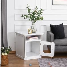 a living room with a gray couch and white side table