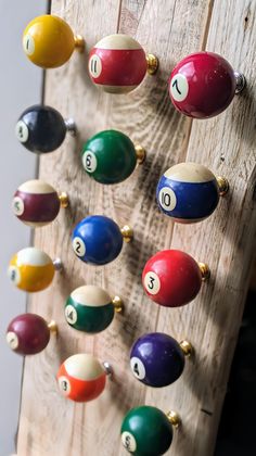 an old wooden rack with pool balls hanging on it's sides and numbers painted on them