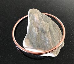 Copper Bangle Bracelet - This is a listing for one handmade pure copper bangle bracelet that fits very comfortably and can be worn daily.  It is forged out of new 8 gauge pure copper wire.  I annealed a single piece of wire, fused the ends, and formed it into the desired size bracelet.  After shaping, it was tumbled in a jewelers mix to polish for a beautiful bright shine and a smooth comfortable wear. This is a very nice bangle bracelet that will offer years of enjoyment. The bracelet pictured Rose Gold Copper Bangle As Gift, Spiritual Rose Gold Bangle Bracelets, Handmade Copper Bangle, Copper Bangle Gift, 7th Anniversary Gifts, 7th Anniversary, Pure Copper, Copper Wire, Bracelets For Men