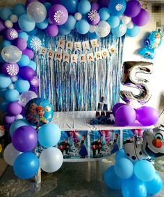 a birthday party with balloons, streamers and decorations for a frozen princess themed celebration