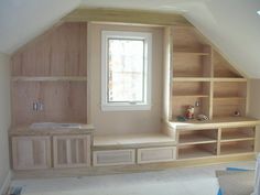 an unfinished room with built in shelves and cupboards