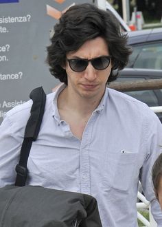 a man with sunglasses and a backpack walking down the street