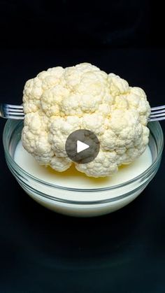 a cauliflower is sitting on a plate with a fork in front of it