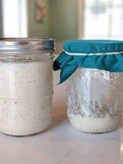 two jars are sitting on a table with blue ribbon around the top one is filled with white powder