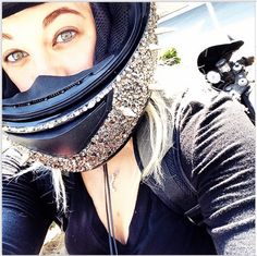 a woman wearing a motorcycle helmet and looking at the camera with her eyes wide open