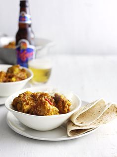 two bowls filled with food on top of a white plate next to tortillas