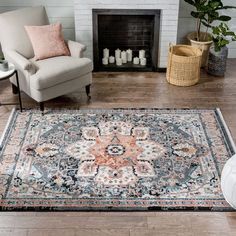 a living room with a fireplace, chair and rug