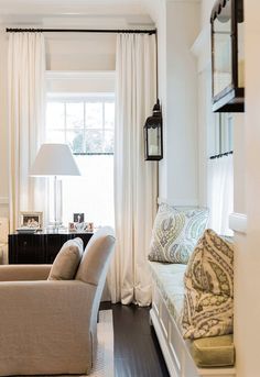 a living room filled with furniture and white curtains