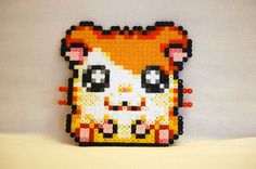 a beaded square with an image of a cat on it's face and eyes