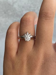 a woman's hand with a diamond ring on top of her finger, showing the center stone