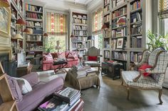 a living room filled with lots of furniture and bookshelves full of books on shelves