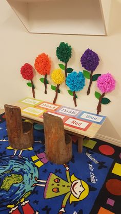 there are flowers on the table and two chairs in front of it, which is decorated with paper flowers