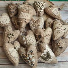 some burlap hearts are arranged on a wooden board with string and other decorations