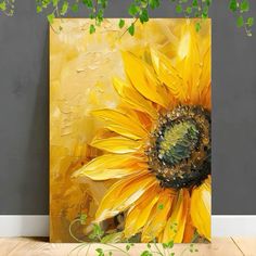 a painting of a sunflower on a gray wall next to a wooden floor and green plants