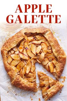 an apple galette is cut into slices and placed on top of a piece of parchment paper