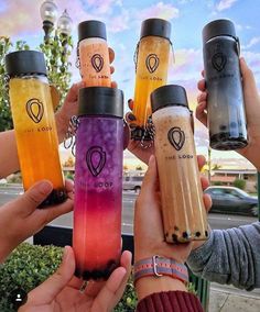 four people holding up their water bottles in front of the camera, while one holds out his hand