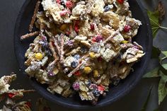 a black bowl filled with cereal and candy cornflakes on top of a table