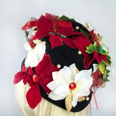 a woman wearing a black hat with red and white poinsettis on it