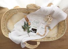 a wicker basket filled with baby items on top of a wooden floor