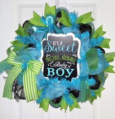 a wreath that says it's a sweet precious adventure baby boy on the front door