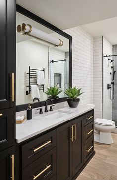 a bathroom with black cabinets and white walls