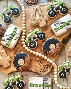 decorated cookies with tractors and farm animals on top of a wooden board next to other decorations