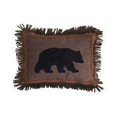 a brown and black bear pillow on a white background