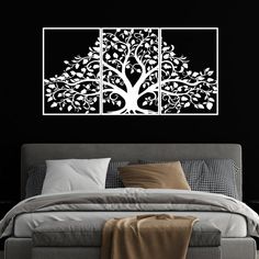 a white tree on a black wall above a bed