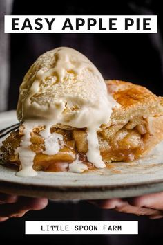 a piece of pie with ice cream on top is being held up by someone's hand