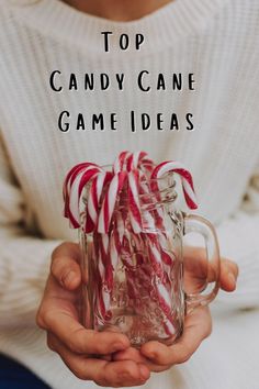 a person holding a glass mug with candy canes in it and text overlay reading top candy cane game ideas