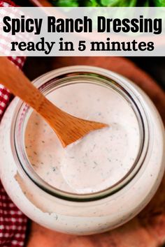 a jar filled with ranch dressing on top of a cutting board