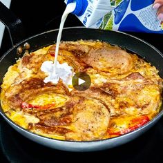 someone pouring milk into a skillet filled with food