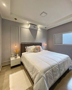 a large white bed sitting in a bedroom next to a night stand with two lamps on it