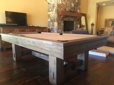 a pool table in the middle of a living room with a fireplace and couches