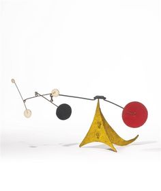 an abstract sculpture with three balls hanging from it's sides