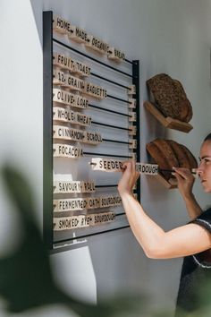 a woman is placing bread on the wall