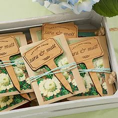 small wooden tags in a box tied with twine and flowers on green tablecloth