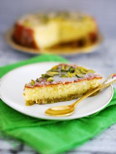 a piece of cake on a white plate with a gold fork and green napkin next to it