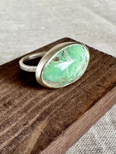 "This turquoise cabochon is bezel set in sterling silver.  The band is hammered and has a matte finish.   Ring size is 6.5 Stone is 5/8\" H x 1\" W" Silver Turquoise Ring With Cabochon Chrysoprase, Handmade Silver Chrysoprase Turquoise Ring, Oval Silver Chrysocolla Turquoise Ring, Oval Turquoise Chrysocolla Ring In Silver, Silver Chrysoprase Cabochon Emerald Ring, Wine Cups, The Band, Atlanta Ga, Bezel Setting