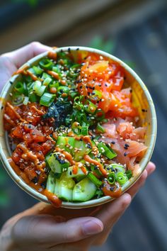 a person holding a bowl filled with different types of vegetables and sauces on top of it