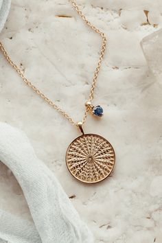 The ascent gold medallion necklace pairs perfectly with our stackable gemstone charm that you can choose from 14 different gemstones to customize it. Perfect for a birthstone of you or someone else. #birthstonejewelry #goldmedallion #goldnecklace #roundpendant #customizablenecklace