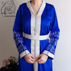 Refined and luxurious caftan in silk cloth, worked in Mremma and Aakad (handcrafted buttons) and decorated with pretty Moroccan embroidery in squelli thread. You can wear it during wedding ceremonies, but also for all occasions such as engagement, henna parties (by the bride or the guest), birth, baptism party, baby shower, Taarouf day . Moroccan belt included. Made to order. Can be made in XS, S, M, L, XL, XXL, XXXL and 4XL (Please see our size guide in the images). Caftan length 1m60cm The cut of the caftan is straight. PRODUCTION TIME: 6-8 weeks. DELIVERY TIME: 2-5 days via FedEX 📸 PICTURES Listing photos are taken in natural light. Depending on your screen definition, colors may vary. ❌All photos of our products are real photos❌ Interview Hand wash in cold water or dry clean. Elegant Blue Thobe For Traditional Ceremonies, Elegant Thobe With Intricate Embroidery For Eid, Elegant Floor-length Embroidered Thobe, Maxi Kaftan With Intricate Embroidery For Traditional Ceremonies, Elegant Maxi Kaftan With Intricate Embroidery, Elegant Ceremonial Kaftan With Dabka, Maxi Length Embroidered Kaftan For Traditional Ceremonies, Elegant Maxi Length Kaftan With Intricate Embroidery, Elegant Maxi-length Kaftan With Intricate Embroidery